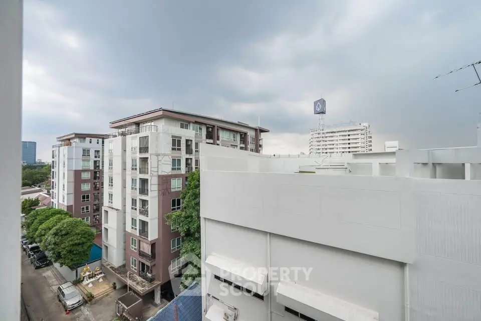 Modern urban apartment buildings under a cloudy sky, showcasing city living.