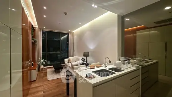 Modern open-layout kitchen and living room with sleek design and ambient lighting.