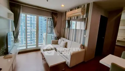 Modern living room with large windows and stylish decor in a high-rise apartment.