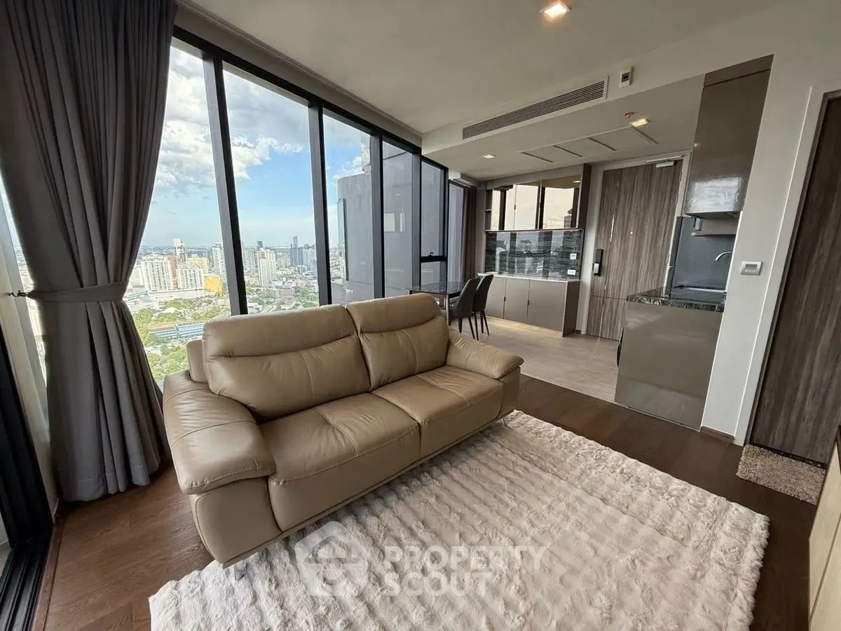Luxurious high-rise living room with stunning city view and modern open kitchen.