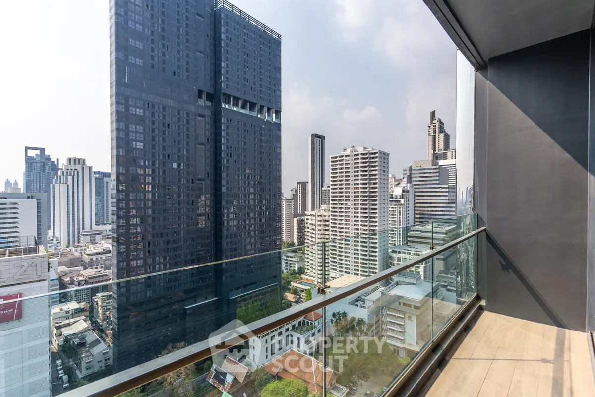Stunning cityscape view from a modern high-rise balcony with glass railing and wooden flooring.