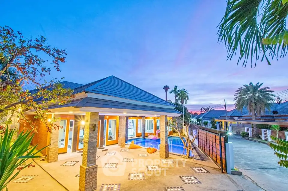 Stunning tropical villa with pool and lush garden at sunset