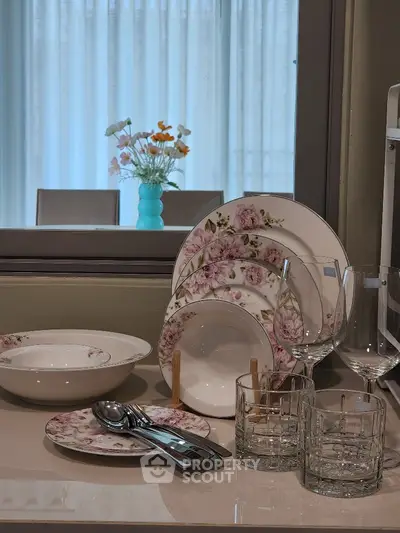 Elegant kitchen setup with floral dinnerware and glassware on a sleek countertop.