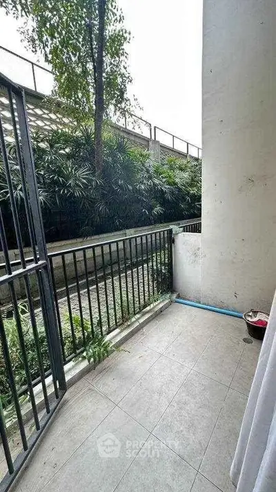 Charming balcony with lush greenery view, perfect for relaxation and outdoor enjoyment.