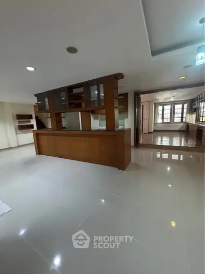 Spacious open-plan living area with modern kitchen and sleek flooring