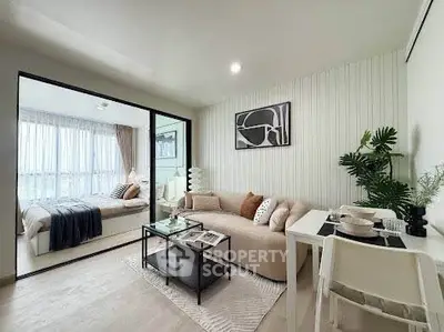 Modern open-plan living room with cozy sofa and stylish decor adjacent to a bright bedroom.