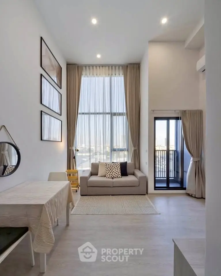 Modern living room with high ceilings, large windows, and elegant decor in a stylish apartment.