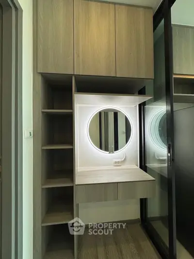 Modern walk-in closet with illuminated vanity mirror and sleek storage solutions.