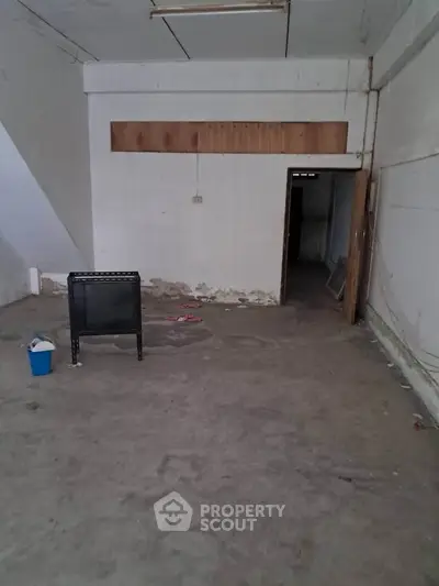 Spacious unfinished room with concrete floor and minimal furnishings, ideal for customization.