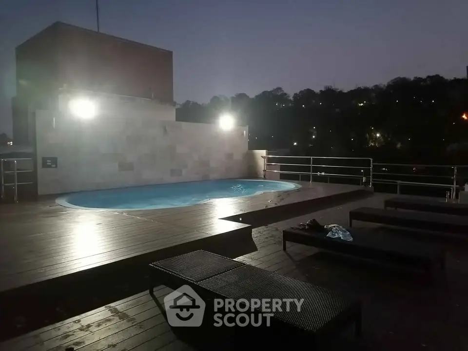 Luxurious rooftop pool with ambient lighting and city view, perfect for relaxation and entertainment.