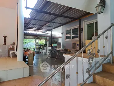 Spacious covered patio with dining area and decorative railing, perfect for outdoor gatherings.