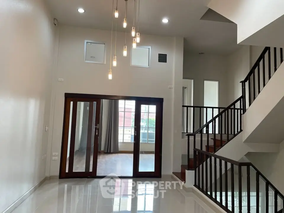 Spacious modern living room with high ceiling and elegant staircase