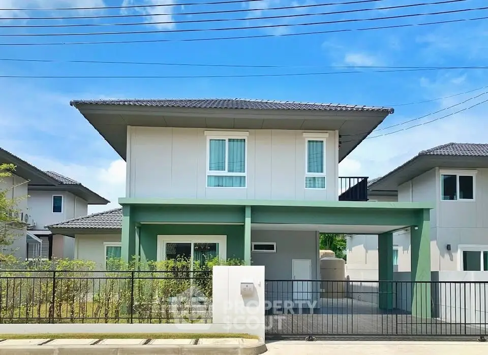 Modern two-story house with green accents and spacious driveway in a serene neighborhood.