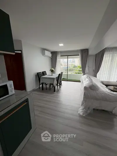 Spacious modern living room with dining area and large windows for natural light.