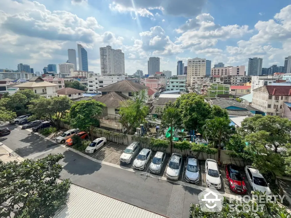 Stunning cityscape view with residential buildings and parked cars under a vibrant sky.