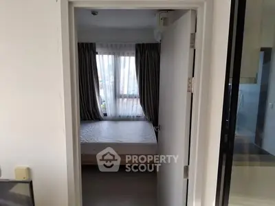 Cozy bedroom with large window and curtains, inviting natural light