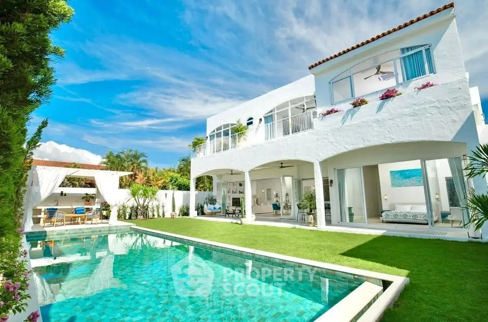 Luxurious white villa with pool and lush garden, perfect for serene living.