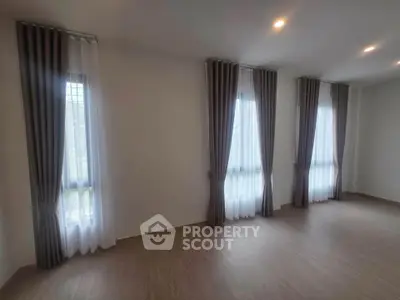 Spacious empty room with elegant floor-to-ceiling windows and modern curtains