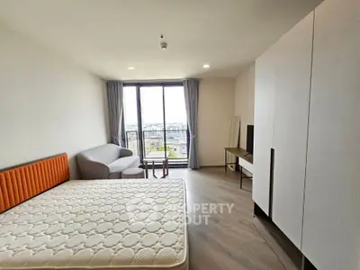 Modern bedroom with large window and stylish furniture in a bright apartment