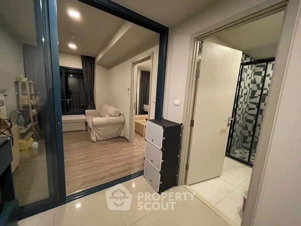 Modern apartment interior with cozy living room and stylish bathroom, featuring sleek design and warm lighting.