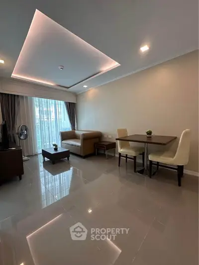 Modern living room with sleek furniture and ambient lighting, featuring a cozy seating area and dining space.