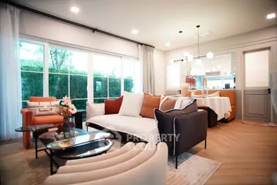 Luxurious modern living room with elegant furniture and large windows offering garden views.