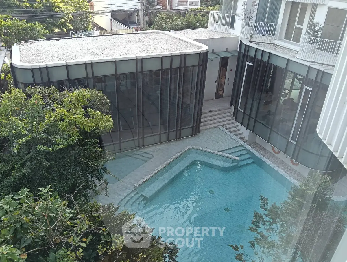 Luxurious modern building with stunning pool view and lush greenery