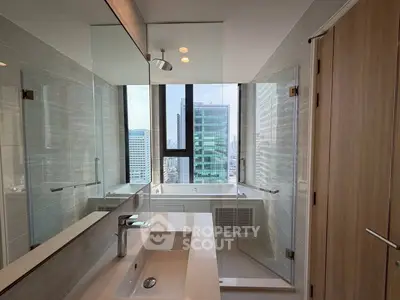 Luxurious modern bathroom with city view, featuring sleek fixtures and glass shower enclosure.