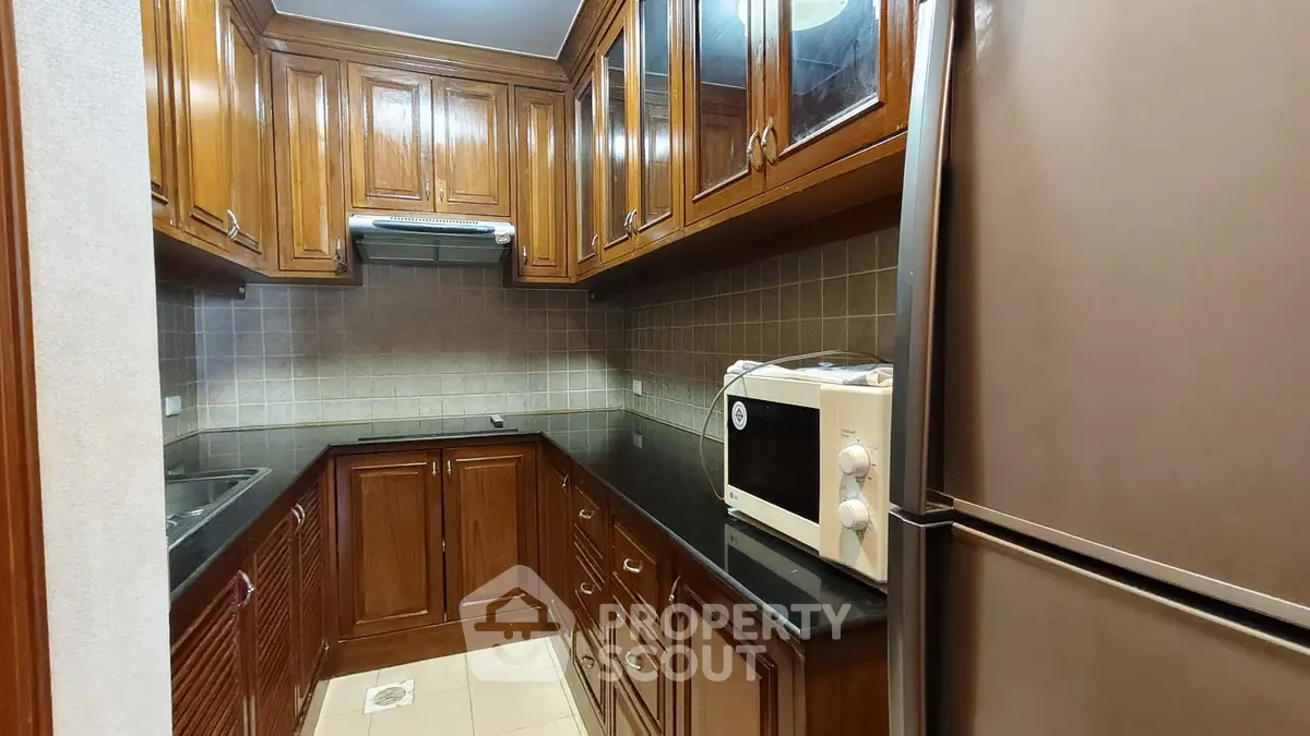 Charming kitchen with wooden cabinets and modern appliances in a cozy apartment.