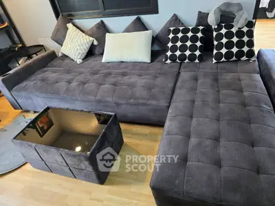 Spacious modern living room with stylish gray sectional sofa and chic decor pillows.