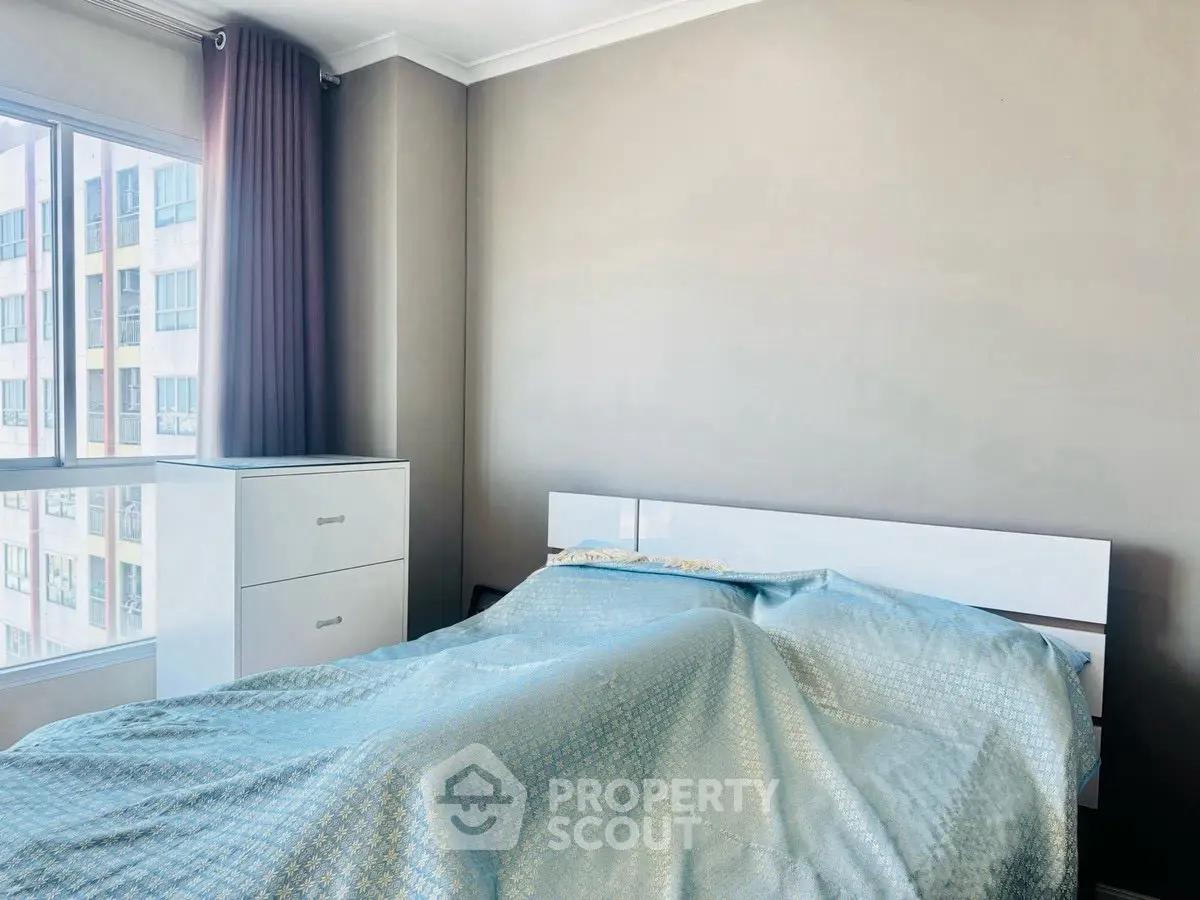 Bright bedroom with large window and modern furniture in urban apartment