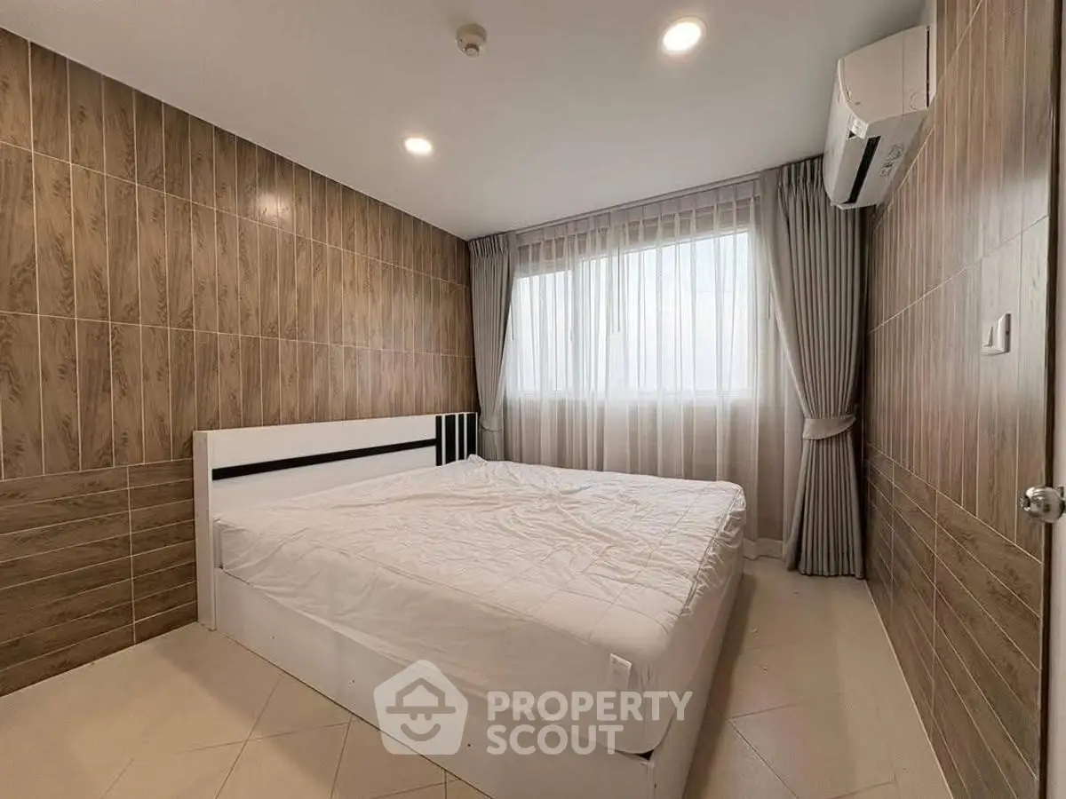 Modern bedroom with stylish wood paneling and large window for natural light