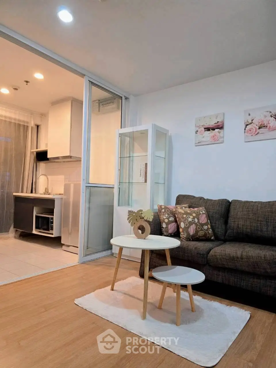 Modern living room with cozy sofa and open kitchen layout, perfect for urban living.