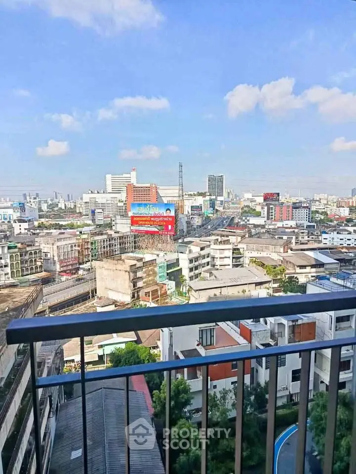 Stunning cityscape view from a high-rise balcony with clear blue skies.