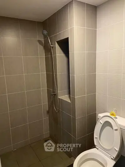 Modern bathroom with sleek tile design and built-in shower area.