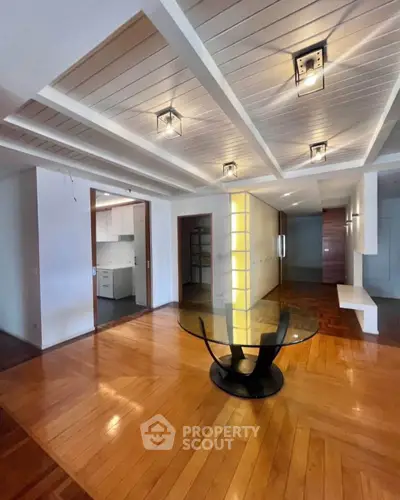 Spacious modern living room with stylish ceiling lights and wooden flooring