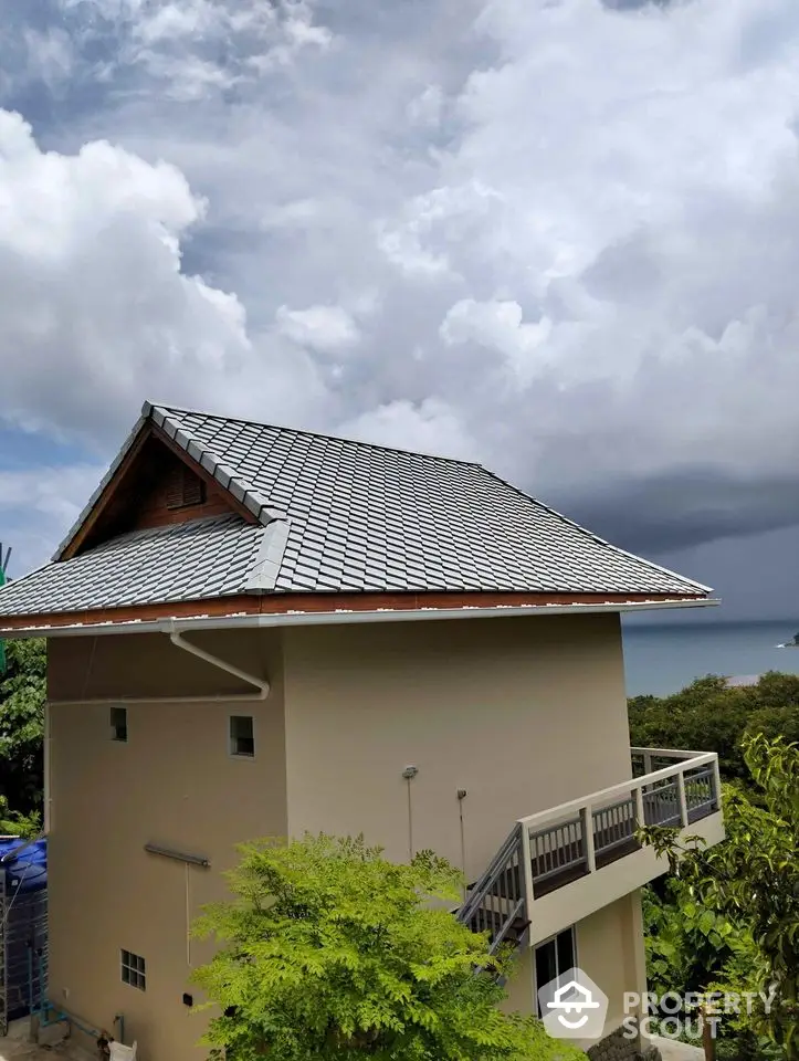 Stunning coastal view from modern hillside home with unique architecture and lush surroundings.