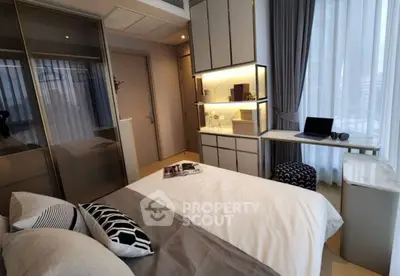 Modern bedroom with stylish decor and natural light, featuring a cozy workspace.