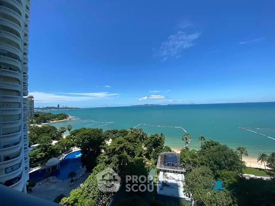 Stunning ocean view from high-rise balcony overlooking lush greenery and blue waters.