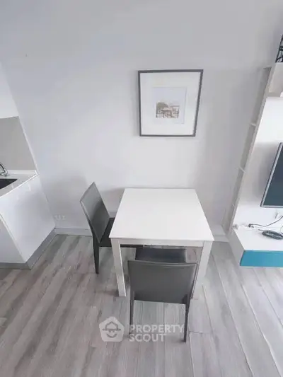 Modern minimalist dining area with sleek table and chairs in a stylish apartment.