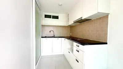 Modern kitchen with sleek white cabinets and black countertops in a compact layout.