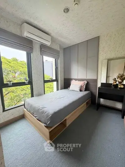 Cozy bedroom with large windows and modern decor, featuring a single bed and air conditioning.