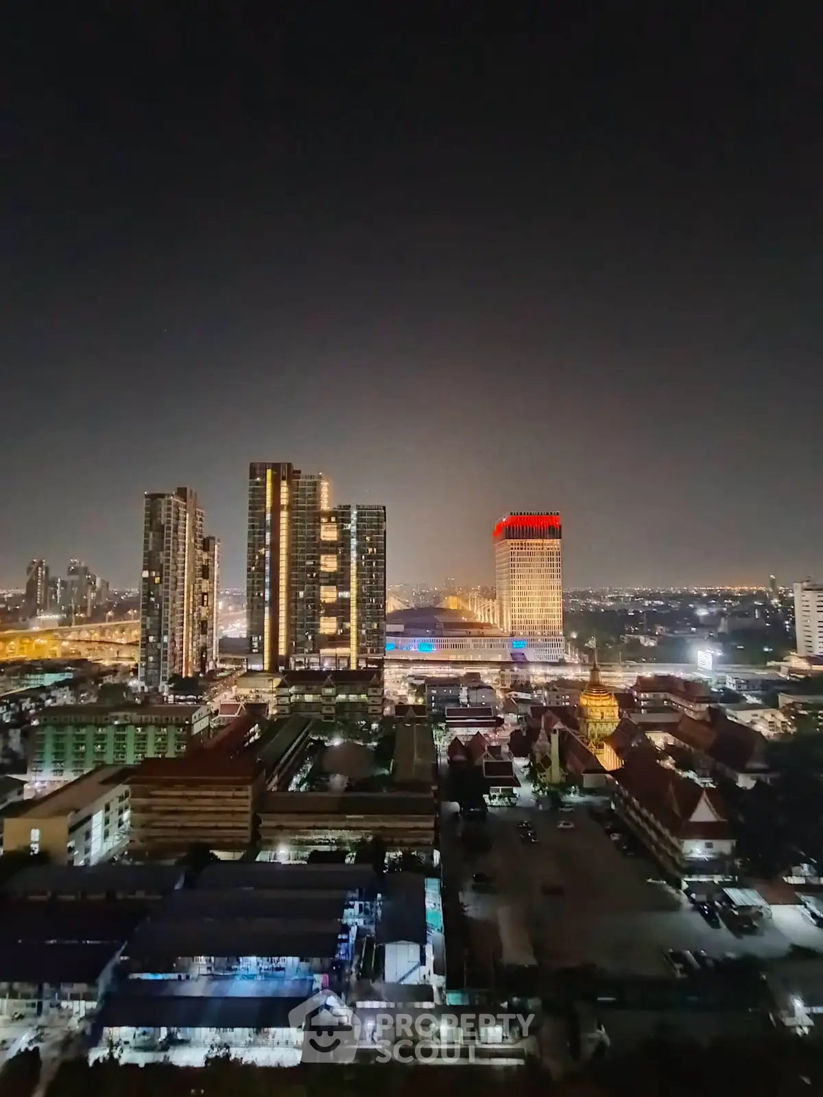 Stunning cityscape view of illuminated skyscrapers at night, showcasing urban living and vibrant skyline.