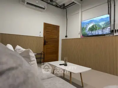 Modern living room with stylish decor and wall-mounted TV, perfect for relaxation and entertainment.