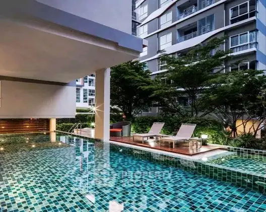 Luxurious condominium pool area with modern design and lush greenery.
