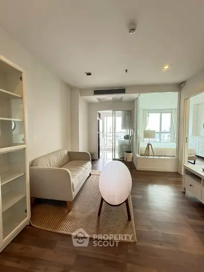 Modern living room with cozy sofa and stylish coffee table, featuring large windows for natural light.