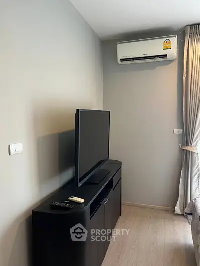 Modern living room with sleek TV stand and air conditioning unit, perfect for cozy relaxation.