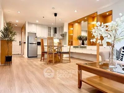 Spacious open-plan living room with modern kitchen and elegant wooden flooring.