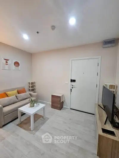 Modern living room with cozy sofa, stylish decor, and sleek TV setup in a contemporary apartment.
