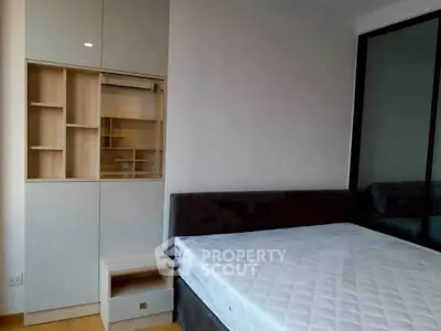 Modern bedroom with built-in storage and large bed in a sleek apartment.